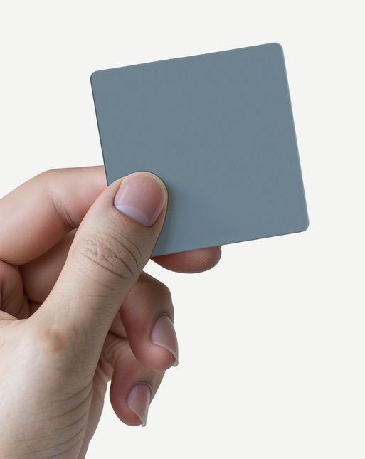 Hand holding a small matte gray sample square Fronten Muster - Matt for IKEA furniture surfaces.